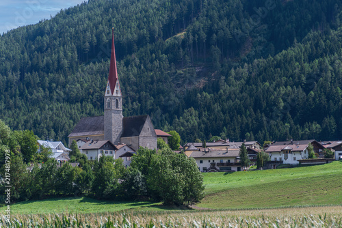 Chiesa di San Leonardo a San Leonardo in Passiria con bosco alpino sullo sfondo, Alto Adige, Italia