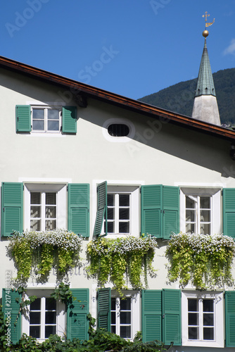 Facciata di casa tirolese con finestre fiorite a Bressanone, Alto Adige, Italia
