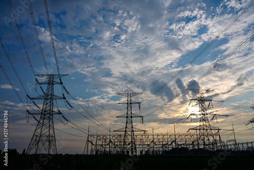 Картината върху платно High voltage transmission tower, power pylon against cloudy blue sky