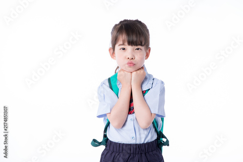 Fotografie Cute young schoolgirl in uniform with backpack pouting on white background