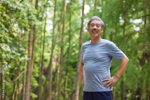 Senior man enjoying outdoor exercise in a green forest park