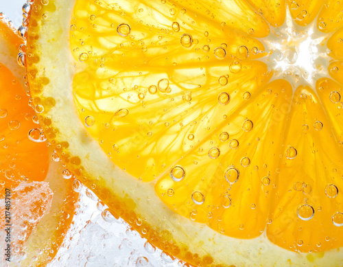 Close up of a juicy orange segment covered with water droplets