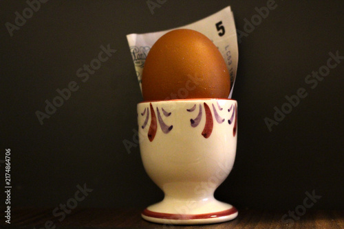 Konstfotografi An egg sits in an egg cup alongside a five-pound note to illustrate changes in f
