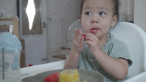 A young child savors a nutritious meal of watermelon and corn, promoting healthy eating habits. The cozy setting reflects a nurturing environment for early food experiences.