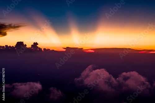 Foto Stunning mountain landscape with crepuscular rays at sunrise above sea of clouds