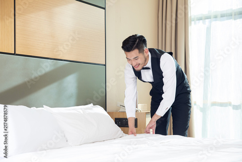 Bild auf Leinwand Hotel staff making bed in modern guest room