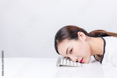 Bild auf Leinwand Exhausted young woman resting on keyboard at desk
