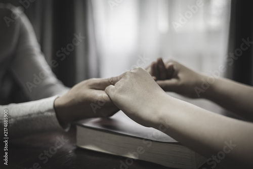 фотографія Two people holding hands during prayer, expressing Christian faith, devotion, hope, love, trust, and belief in God