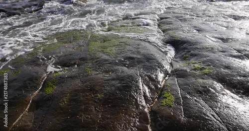 Close up of Atlantic ocean waves crashing on rocky shoreline