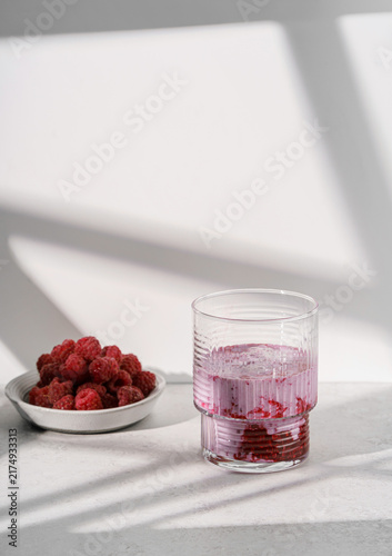 Fresh raspberry puree with milk on a light background.