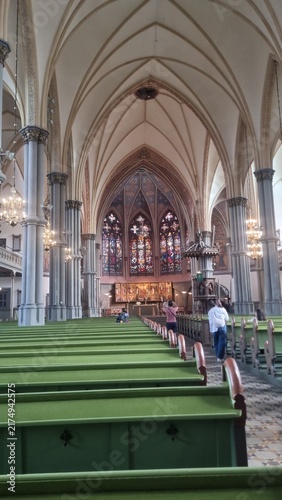 Foto Interior of a Gothic-style church with high vaulted ceilings and stained glass w