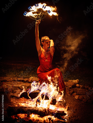 Woman Performing a Mystical Fire Ritual with Flaming Fan at Night.