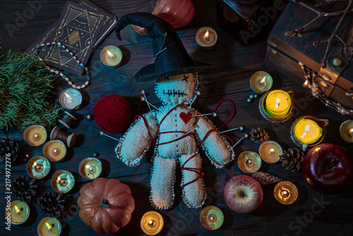 Fotografía Witch wizard witchcrafting, performing ritual with handmade voodoo doll among candles, pumpkins