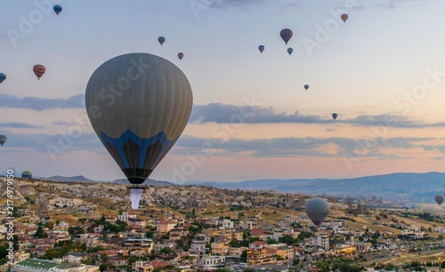 Hot air balloons flying over rocky valley at sunset. Hot air ballooning represents freedom exploration dream.