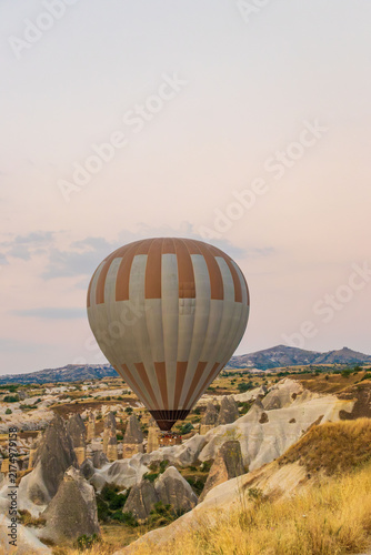Hot air balloons flying over rocky valley at sunset. Hot air ballooning represents freedom exploration dream.