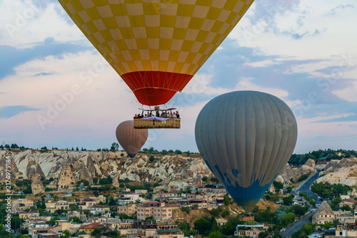 Hot air balloons flying over rocky valley at sunset. Hot air ballooning represents freedom exploration dream.