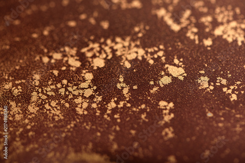 Artistic background featuring reddish-brown swirls with gold accents; photo of the surface.