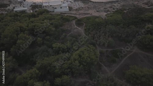 Aerial drone perspective of Punta della Suina beach resort and coastline in Gallipoli, Puglia. Crystal clear turquoise water and Mediterranean scrub at sunset.