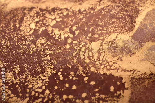 Artistic background of reddish-brown swirls with gold accents – close-up photo