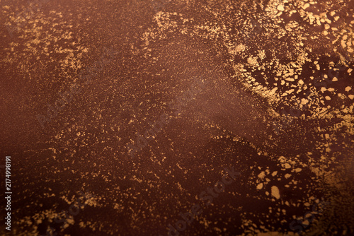 Artistic background featuring reddish-brown swirls with gold accents; wide shot.