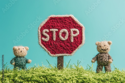 Red knitted stop sign with teddy bears on a light blue background.