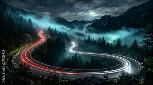 Winding mountain highway at night in thick glowing fog, long exposure car light trails on curved asphalt, eerie cinematic scenery.