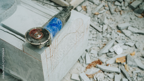 Canvastavla Angle grinder resting on partially carved stone sculpture with debris in artisan