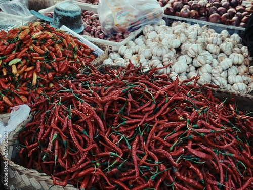 Canvastavla Fresh red curly chili peppers garlic bulbs and red shallots at Indonesian market