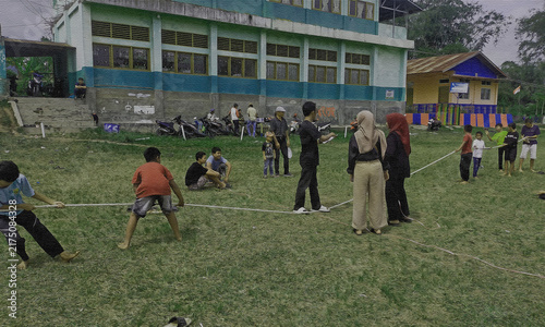 Children playing traditional tug of war game in school yard for independence day celebration competition