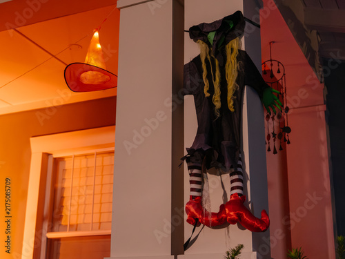 Foto A colorful witch decoration hangs from a porch column during Halloween evening