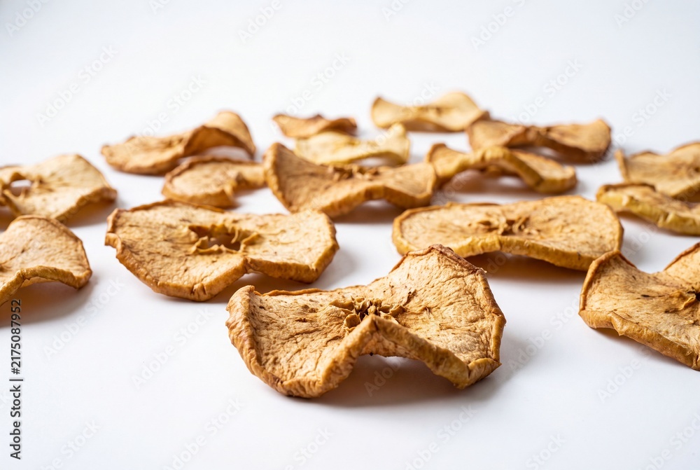 Fototapeta premium Dried Apple Slices Scattered as Healthy Organic Snack on a Plain White Background