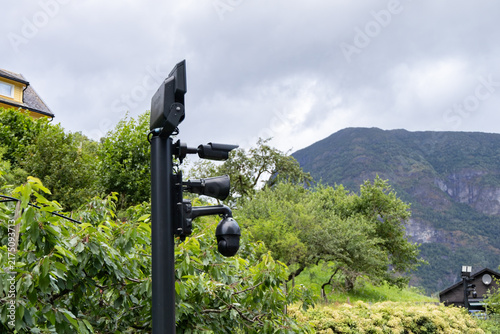 Photography Video surveillance camera system mounted on a pole in a green outdoor area with