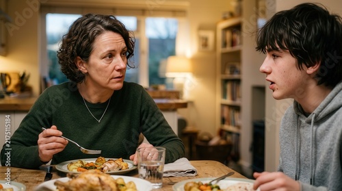 Serious Mother And Teenage Son Having A Meaningful Conversation During A Homemade Family Dinner At Home