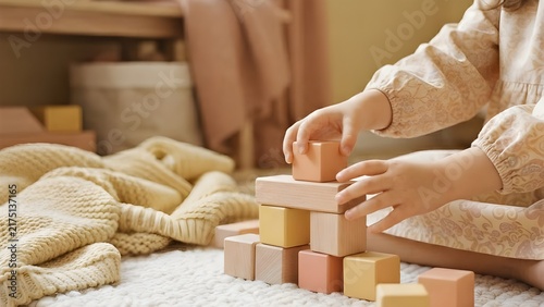 아이가 따뜻한 실내에서 나무 블록을 가지고 노는 포근하고 다정한 손길의 풍경
A cozy and tender scenery of a child's hands playing with wooden blocks indoors