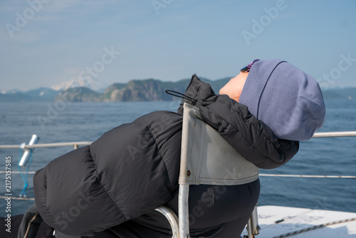 Принти на полотні Woman sleeps on catamaran during sea trip in Kamchatka after taking motion sickness medication causing drowsiness