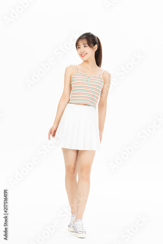 Fotografie Smiling young woman posing in striped camisole and white skirt