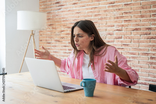 Konstfotografi Young woman feeling frustrated and angry while working from home, reacting to a