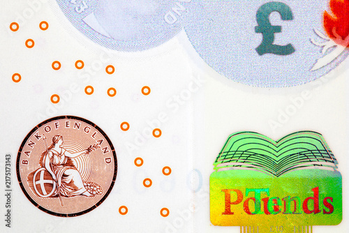 British 10 ten pounds polymer banknote, showing the Bank of England seal featuring Britannia, a holographic book emblem with word-changing foil, and security print elements, representing UK currency