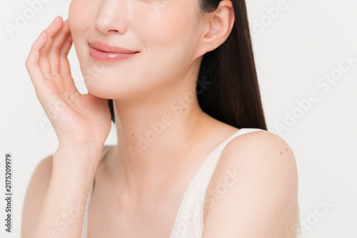 顔に手を添える黒髪ストレートヘアの若い日本人女性。スキンケアイメージ。