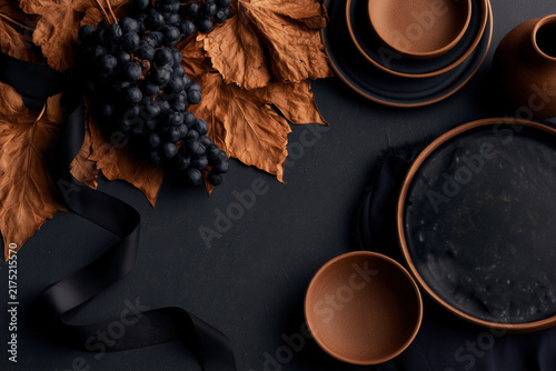 Autumn tabletop with grapes and ceramic dishes