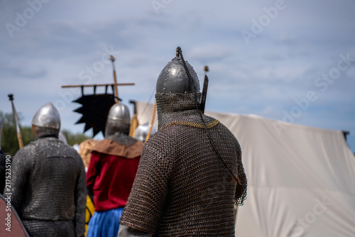 Cuadro en lienzo Medieval warriors wearing steel chainmail armor and pointed helmets seen from behind during a historical reenactment festival outdoors