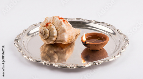 Conch Shell and Lit Earthen Diya Lamp on Silver Plate for Janmashtami