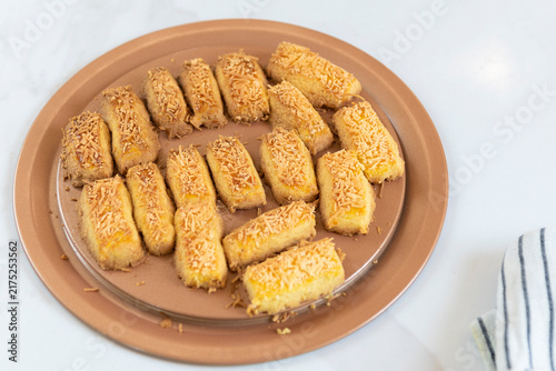 Foto Golden baked rectangular pastries arranged in rows on a white plate, photographed for a clean food presentation