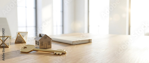Miniature house model and golden key on wooden table, representing real estate investment strategy and property ownership planning.