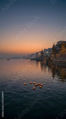 Ganges river at sunset with floating lights and temples