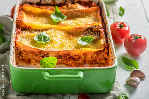 Принти на полотні Tasty lasagna with fresh basil, tomatoes, and parmesan.