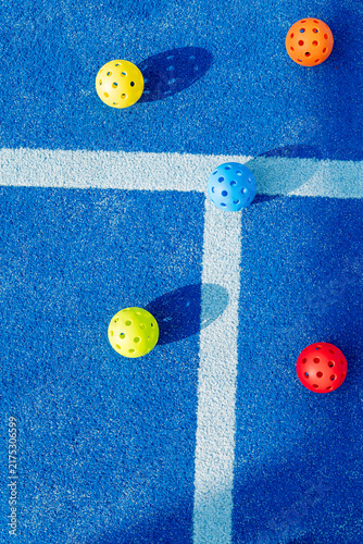 Colorful pickleball balls on blue court turf The Concept of modern sports and active recreation