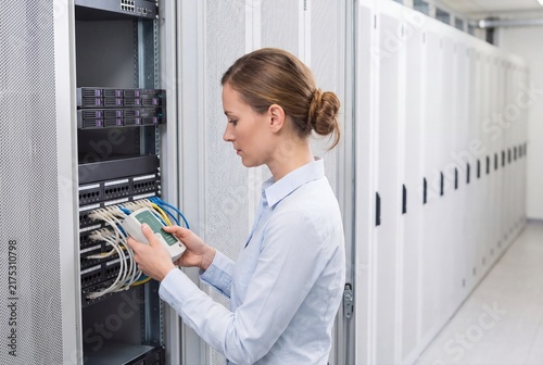 Plakat Female IT engineer testing network cables in datacenter server room