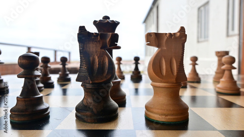 Obraz na plátne A traditional wooden chess game depicting a strategic confrontation between two opposing sides, symbolizing the struggle for territory, resources, political power, tactical planning, and dominance