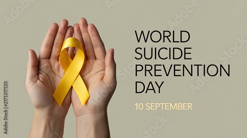 Hands holding a yellow ribbon for suicide prevention day